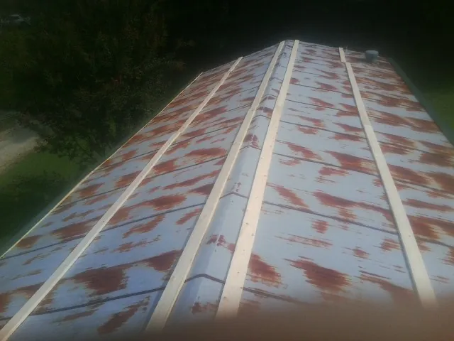 Rusted metal roof panels with new wood purlins before replacement — Storm Damage Roof Repair in Olaton by Roofing Brothers