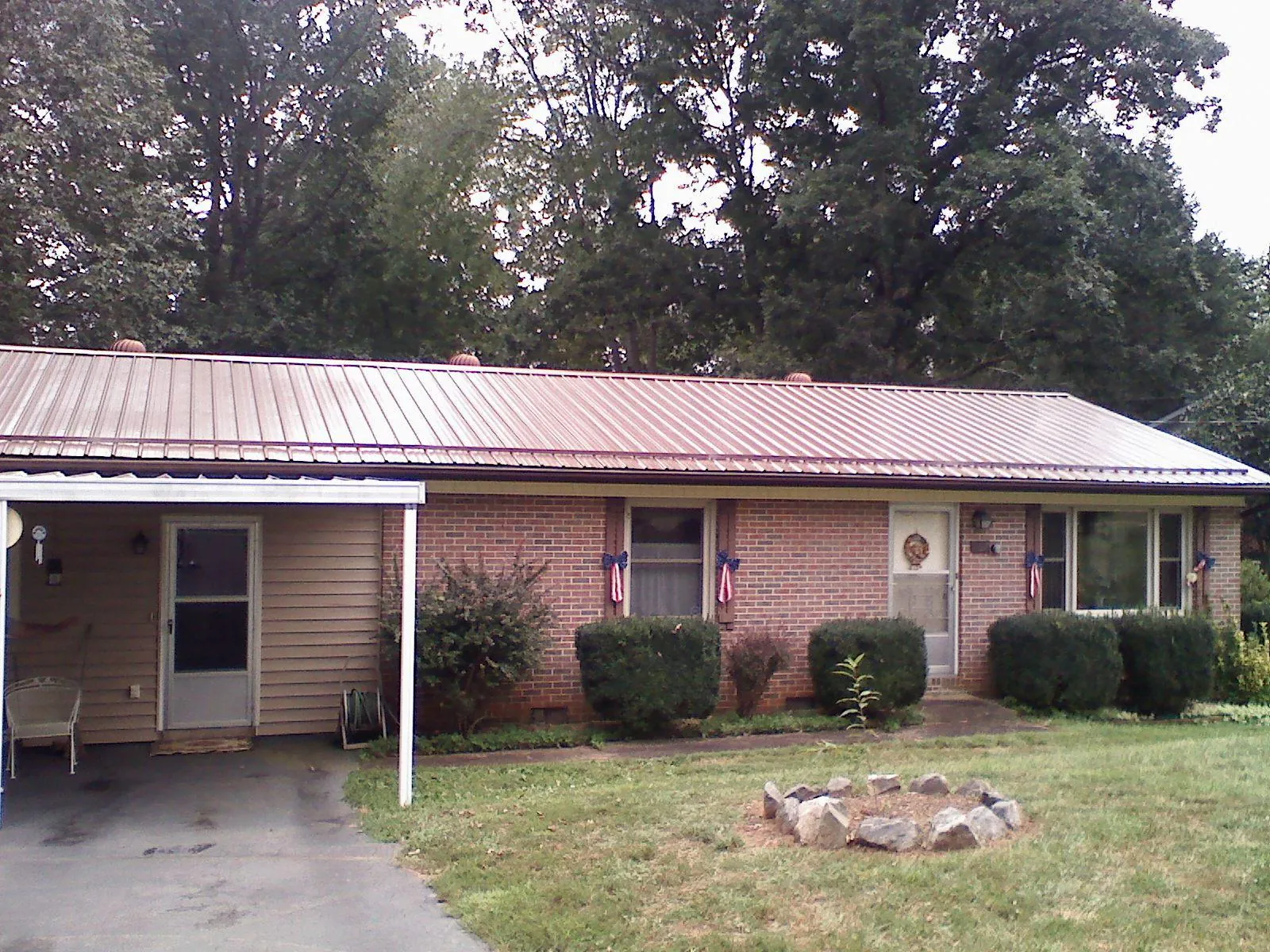 Bronze metal roof and carport on a brick ranch home — Roof Repair work by our crew in Olaton